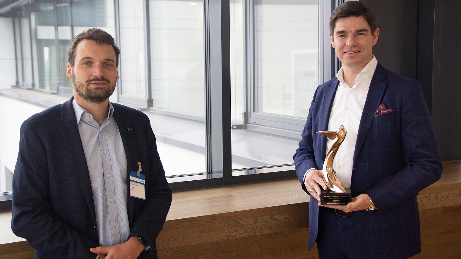 The Architects' Darling 2020 in gold in the stair category for the Schöck Tronsole®: Daniel Sigwarth, Area Sales Manager Marketing Services at Heinze (left), presents the coveted trophy to Mike Bucher, Chairman of the Board of Schöck AG.